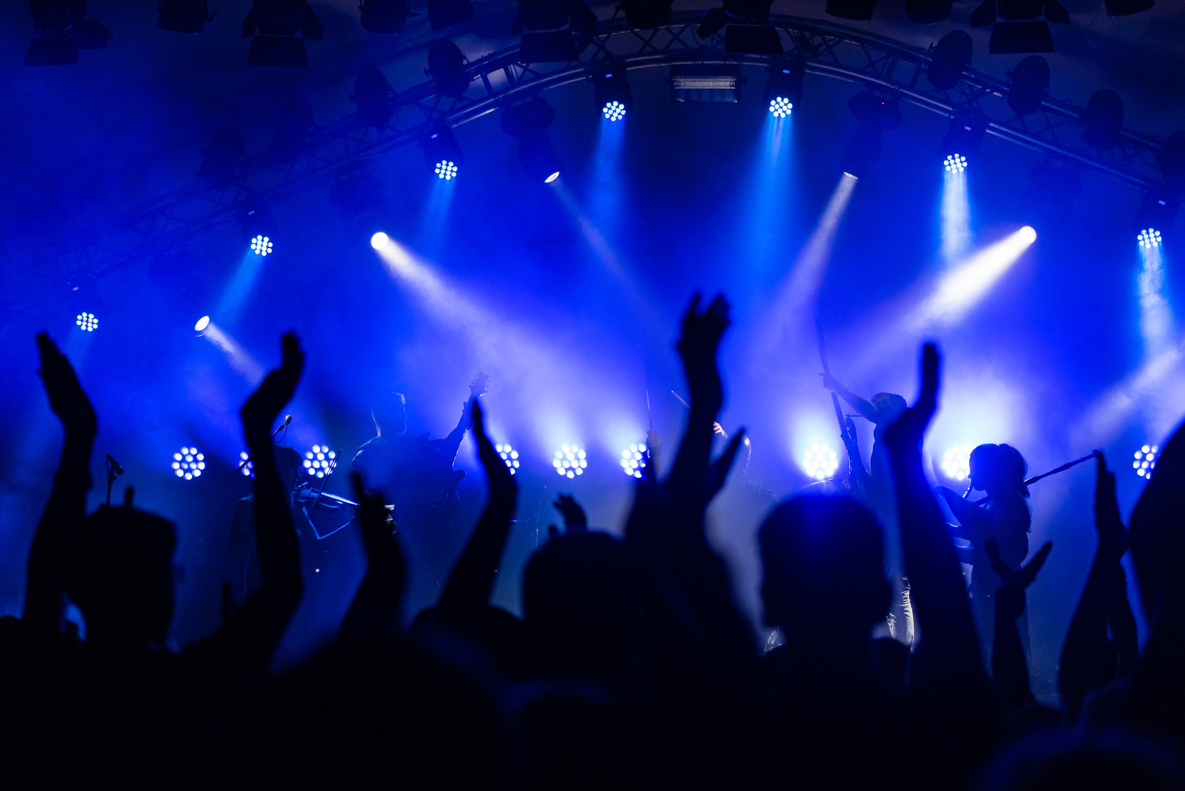 A band on stage performing in front of a cheering crowd